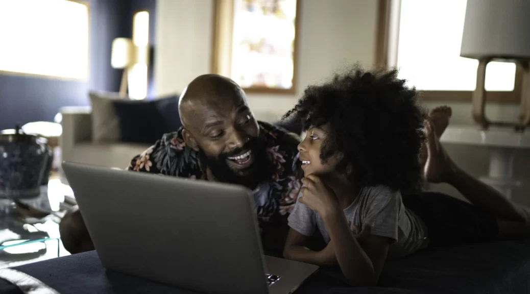 Single Father Watching Movie on a Laptop With His Daughter